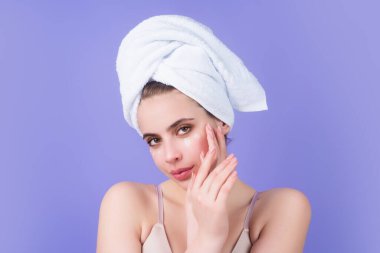 Young woman applying body cream against studio background. Beauty routine. Studio face of a beautiful woman with perfect skin. Wrinkle cream. Concept of beauty. Woman applying face cream