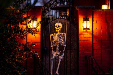 Cadılar Bayramı sezonu. Cadılar Bayramı balkabağı ve dekore edilmiş ev için iskelet. Bir Amerikan evinin ön bahçesinde dekore edilmiş korkunç bir şey. Şeker mi şaka mı? Cadılar Bayramı geçmişi. Cadılar Bayramı 'nın sonbahar tatili