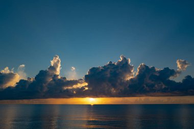 Dramatik gün batımı gökyüzü. Deniz. Bulutların arasından gün batımını izleyen sakin bir deniz. Meditasyon okyanusu ve gökyüzü arka planı. Huzurlu deniz manzarası. Günbatımı deniz suyunun üzerinde bir ufuk. Gün batımı gökyüzü sakin