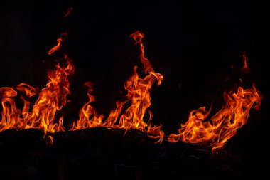 Siyah arka planda yangın alevleri. Ateş, izole edilmiş, soyut bir yapı. Yanma efektiyle yanan bir patlama. Duvar kağıdını ateşle, kopyalama alanı ile soyut sanat deseni