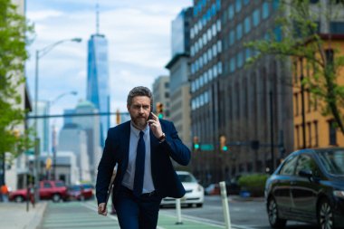 New York 'ta telefonu olan takım elbiseli bir adam. İş konuşmaları. İş adamı caddede koşup telefonla konuşuyor. Takım elbiseli adam geç kaldı. İş görüşmesi. İşletme adamı. Hızlı iş. Koş ve geç iş adamı
