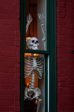 Cadılar Bayramı iskelet süslemeleri. Dekorasyon için cadılar bayramı iskeleti. Bir Amerikan evinin ön bahçesinde dekore edilmiş korkunç bir iskelet. Şeker mi şaka mı? Cadılar Bayramı iskelet arka planı