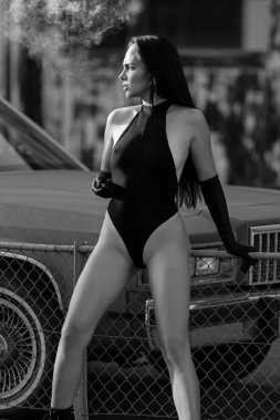 Esmer güzeli model kız dışarıda eski arabanın yanında poz veriyor. Seksi, çekici kadın portresi, seksi iç çamaşırları, moda kıyafetleri. Güzellik trendleri. Moda blogçusu