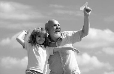 Büyükbaba ve oğlu oyuncak kağıt uçakla oynuyor. Uçma hayali kuran çocuk. Aile İlişkisi Büyükbaba ve Çocuk