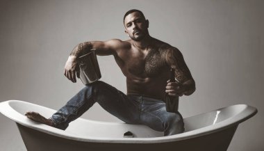 Stresli bir iş gününden sonra rahatlamanın en iyi yolu. Atheltic İspanyol adam dinlenmek için şampanya içiyor. Fit gövde dövme ile Güçlü latino adam dinlenmek ve banyo keyfini çıkarın. Stres giderici spa dinlenmek.