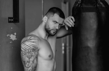 Spor salonunda güçlü bir boksör. Spor kulübünde kum torbasıyla spor erkek antrenmanı. Sıkı boks. Genç adamın fitness antrenmanı var. Erkek sporcu spor yapar.