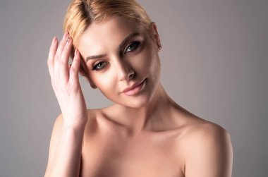 Güzel yüzlü, pürüzsüz ciltli, çıplak omuzlu, şehvetli bir kadın. İzole edilmiş stüdyo arka planında doğal makyajlı ve güzel gözlü seksi bir model. Çıplak omuzlu güzel seksi manken kız.