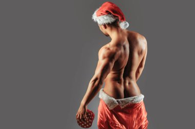 Christmas sexy man with gift. New year strip and gifts for adults. Muscle man torso with sexy buttocks butt. Santa with muscular body back