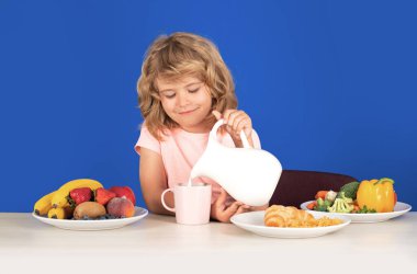 Çocuk bütün inekleri sağıyor. Çocuk portresi evde taze sağlıklı yiyecekler yiyor. Çocuk okuldan önce kahvaltı yapıyor.