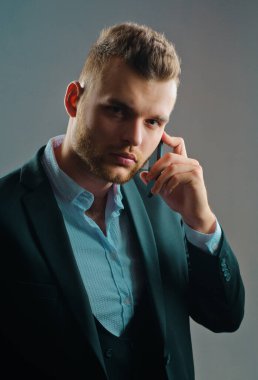 İşadamı telefon mobil ile çalışıyor. Lüks klasik takım elbiseler, moda. Erkek takım elbisesi modası. Toplantı telefonu