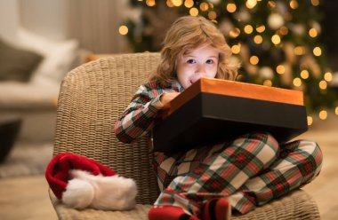 Noel 'i kutlayan küçük bir çocuk ya da evde Noel ağacı olan bir çocuk.