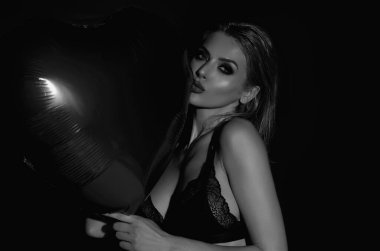 Stüdyo izole edilmiş arka planda kalp şeklinde hava balonu olan güzel seksi kadın. Sevgililer gününde şehvetli bir kadın. Kalp aşkı. Kızda kırmızı balon kalbi var. Tatil partisi, doğum günü. Kalp aşkı konsepti