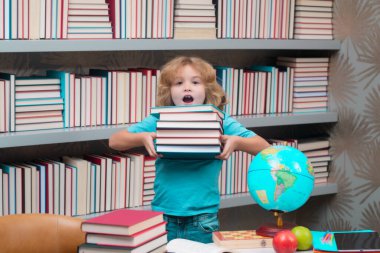 Kütüphanede yığınla kitabı olan okul çocuğu. İnek öğrenci. İlkokuldan zeki bir çocuk. Zeki dahi zeki çocuk öğrenmeye hazır.