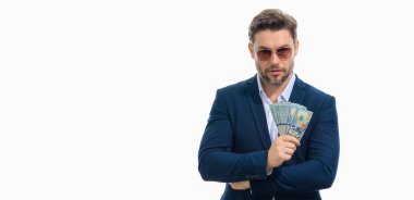 Üzerinde nakit para banknotları olan tişörtlü bir iş adamı sarı stüdyo geçmişinden izole edilmiş. 100 dolarlık banknot, finansal konsept.