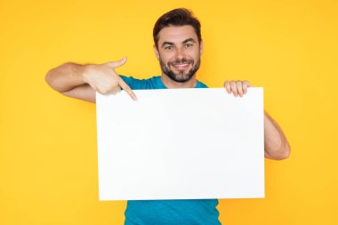 Bilgi konsepti. Boş pankartlı bir adam. Metnin ya da tasarımın için kopyalama alanı gösteriliyor. Stüdyo arka planında boş reklam panosu gösteren bir adam. Boş pano, reklam tabelası.