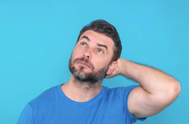 Stüdyonun izole edilmiş arka planında kafası karışmış düşünen bir adamın portresi. Düşünen adam, düşünceli yüz, düşünceli yüz. Şüpheli bir kavram. Ciddi ifade, şüphe ve seçim