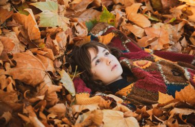 Sonbahar zamanı. Güz yaprağında güzel bir genç kadının portresi. Güzel bir sonbahar tatili geçirmiş genç bir kadın. Kızlar sonbahar ormanlarında doğanın tadını çıkarırlar. Sonbahar günü. Açık hava.