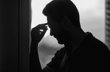 Yorgun adamın korkunç bir baş ağrısı var. Bitkin, sağlıksız hisseden, baş ağrısı hastalığına üzülen bir adam. Stresli orta yaşlı bir adamın baş ağrısı olan portresi. Migren ve baş ağrısı konsepti