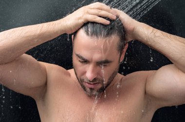 Adam sabah duşu alıyor. Duş başlığından dökülen saçlar. Duş alan adamı kapatın. Vücut bakımı hijyeni. Duş konsepti. Adam duşta su altında.