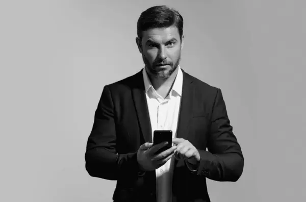 stock image Business man in suit watching on mobile phone. Handsome man wearing formal wear using smart phone, type sms message. Social network. Handsome businessman using mobile phone, talking on phone