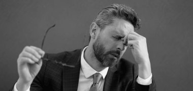 Çok çalışan bir adam migren ağrısı çekiyor. Sıkılmış adamda ofis sendromu var. Yorgun adam dizüstü bilgisayarda migrenle ya da baş ağrısıyla boğuşuyor. Ofis çalışanı, yönetici serbest çalışan. Başı ağrıyor.