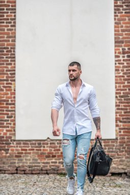 Dışarıda yürüyen seksi özgürlük adamı. Tasasız ve özgürlükçü adam. Seksi gömlek çantası olan adam. Bagaj çantalı üstsüz özgürlük adamı. Özgürlük ve macera