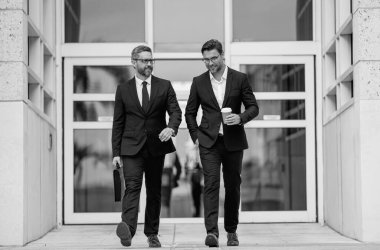 İş adamları sokakta yürür. Ofis binasında yürüyen ve konuşan iki işadamı. Takım elbiseli iki Amerikalı iş adamı şehirde dışarı çıkıp iş konuşuyorlar. Başarılı iş konsepti