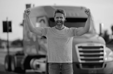 Kamyonun yanında erkek sürücü var. Kamyon şoförü. Kamyon sahibi. Nakliye araçları. Kamyonun önünde poz veren yakışıklı bir adam. Yarı kamyon aracı