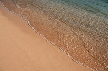 Kumlu sahilde mavi okyanus dalgası. Yaz mevsiminde gün batımında plaj. Plaj manzarası. Tropik deniz manzarası, sakinlik, dinlendirici güneş ışığı