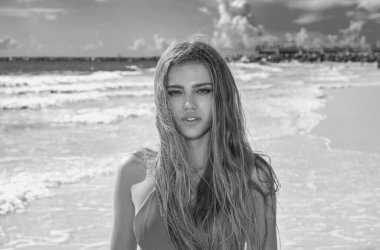 Outdoor lifestyle portrait of beautiful young woman on the beach. Natural beauty. Travel and youth. Summer vibes. Freedom and carefree concept. Sexy fashion woman playing on seashore