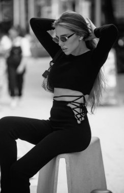 Moda mankeni. Yaz şehrinde güzel bir kadın model. Sokakta poz veren modaya uygun bir kadın. Moda modelleri modaya uygun elbiseler giyer. Zarif elbiseli şık bir genç kız.