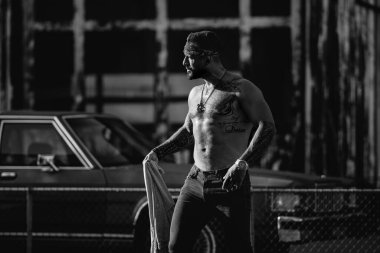 Sokaktaki güçlü kaslı hippi modeli. Üstsüz adam. Moda erkeği sokakta poz veriyor. Şehir sokağındaki kızgın adam. Tehlikeli agresif adam. Suç şehri. Tehlikeli Amerikan bölgesi. Saldırgan adam.