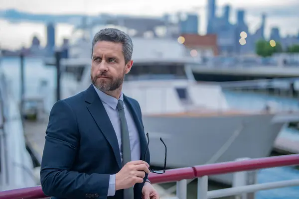 Stock image Business man in suit posing outdoor in NY. Business American success. American business dream. American businessman in suits near office building and yacht. Business in USA