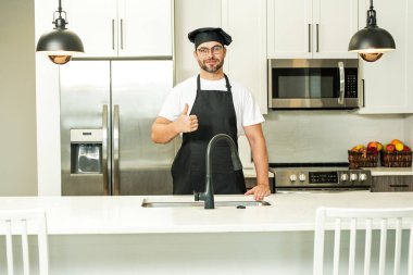 Mutlu fırıncı, baş parmak yukarıda. Mutfakta şef şapkası takmış şefin portresi. Önlük, şef üniforması ve aşçı şapkası takan bir adam. Karakter mutfakçısı, reklam şefi.