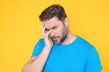 Başı ağrıyan bir adam, stüdyo portresi. Yorgun adamın başı ağrıyor. Bitkin, sağlıksız hisseden, baş ağrısı hastalığına üzülen bir adam. Migren ve baş ağrısı konsepti. Migren.