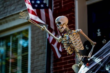 Cadılar Bayramı süslemeleri. Amerikan evi için Cadılar Bayramı balkabağı ve iskeleti. Bir Amerikan evinin ön bahçesinde dekore edilmiş korkunç bir şey. Şeker mi şaka mı? Amerika 'da Cadılar Bayramı. Amerika 'da Cadılar Bayramı