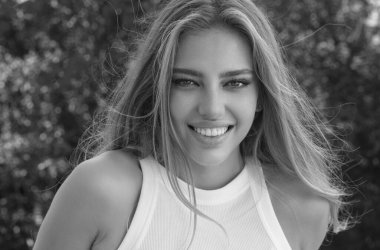 Doğal makyajlı ve kusursuz temiz tenli genç bir kadının moda portresi. Yazın dışarıda poz veren seksi bir model. Moda saç stili olan bir kız. Güzel kadın yüzü. Yakından.