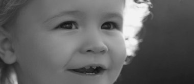 Neşeli çocuğun yakın plan portresi. Sevimli, neşeli, makro suratlı bir çocuk. Hayalci çocuk suratı. Hayalperest çocuk portresi yakın plan. Hayaller ve hayal gücü. Hayalci okul çocuğu suratı.