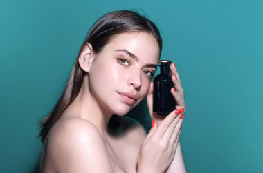 Parfüm şişesi. Kokulu parfümlü bir kadın. Kadın parfüm şişesi tutuyor. Parfüm kullanan güzel bir kız. Parfüm şişesi olan kadın. Kadın parfüm sunar.