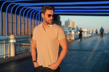 Şehir caddesinde yürüyen, faşist kıyafetli yakışıklı bir adam. Büyük şehirde başarılı bir erkek model şehir yaşamını sürdürüyor. Sokakta yürüyen genç erkek manken. Sokaktaki genç İspanyol adam.