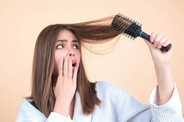 Hair loss woman with a comb and problem hair. Hairloss and hairs problems. Sad girl with damaged hair. Haircare and loss hair problem. Tangling hairs. Girl combing damaged hairs. Alopecia, dandruff