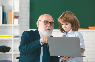 Online dersler. Öğretmen öğrenmeye yardımcı olur. Öğrenci çocuk sınıfta öğreniyor. Eğitim, öğretmenlik. Öğrenci çocuk dersi.