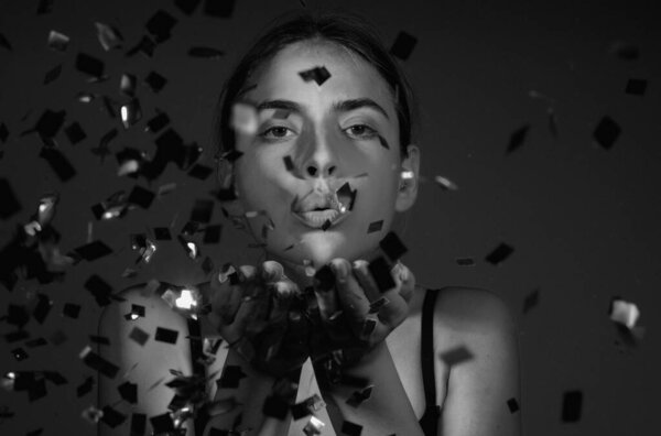 С днем рождения. Студийный портрет девушки, дующей конфетти. Конфетти на день рождения или валентинки. Сексуальная модель отсосала конфетти на день рождения. Чувственная женщина празднует день рождения с конфетти