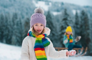 Doğada kış yürüyüşünde oynayan tatlı çocuklar ve kızlar. Kış kıyafetleri giymiş mutlu çocukların portresi.