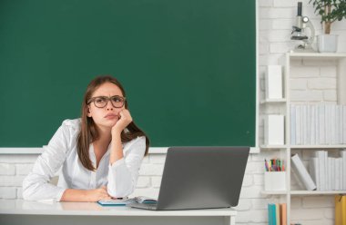 Üzgün, ciddi ve ilgili bir okul kızı. Lise öğrencisi sınıfta İngilizce veya matematik öğreniyor