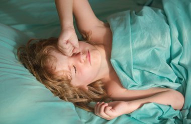 Evde yatakta uyuyan sevimli çocuklar.