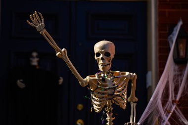 Cadılar Bayramı geçmişi. Cadılar Bayramı balkabağı ve dekore edilmiş ev için iskelet. Bir Amerikan evinin ön bahçesinde dekore edilmiş korkunç bir şey. Şeker mi şaka mı? Cadılar Bayramı geçmişi. Cadılar Bayramı 'nın sonbahar tatili