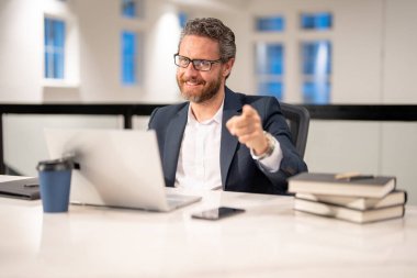 Ofiste bilgisayarı olan bir ofis çalışanı. Modern ofiste çalışan uzaktan kumandalı bir çalışan. Uzaktan kumandalı bir iş adamı, ofislerde online çalışıyor. Ofiste bilgisayar kullanan bir iş adamı.