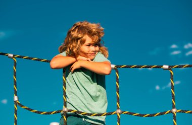 Oyun arka planında kaya tırmanışı yapan sevimli bir çocuğun portresi.