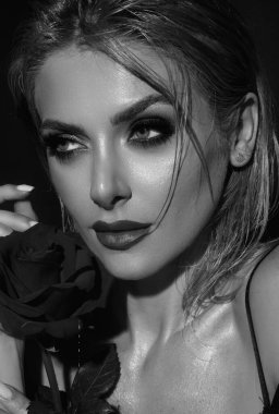 Bright make-up close up face. Valentines day, celebration and beauty concept. Charming romantic young woman with flowers, studio background